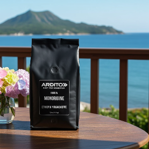 A black bag of ARDITO Monorigine Ethiopia Yirgacheffe coffee sits on a wooden table outdoors, with a scenic ocean and mountain background.